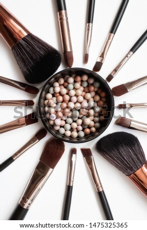 Makeup brushes and powder, forming a circle on a light background. Horizontal template for make-up artist business card or flyer design.