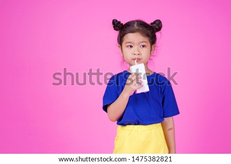Happy little asian girl holding box of milk, Isolated over white