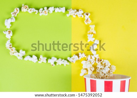 Top high above angle overhead close up view photo of popcorn with read and white striped bag making shape of speech bubble isolated over colorful background