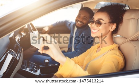 Happy african american couple taking selfie in car, driving to new destination, free space