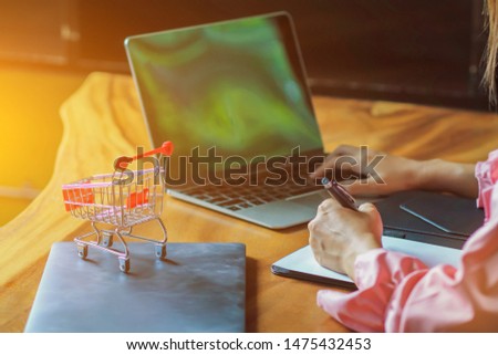 blurred photo,Young women are calculating the costs incurred by online shopping via credit cards.
Convenience concept with online shopping through Application and payment of products via credit card