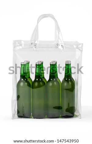 Photo of several cold beers in a transparent plastic bag, with working path. The beers are in green bottles and in  colorless bag isolated on white background. 