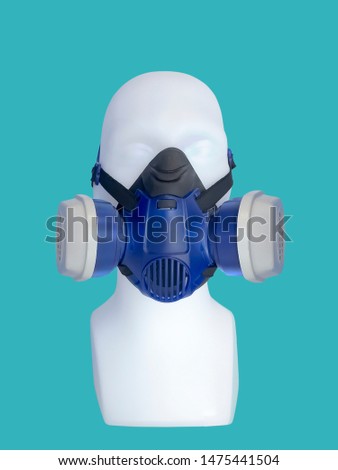 Mannequin wearing protective dust mask with valve over green background.