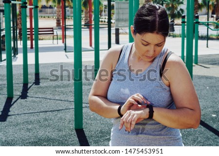 young brunette girl exercising in a park with fitness bars