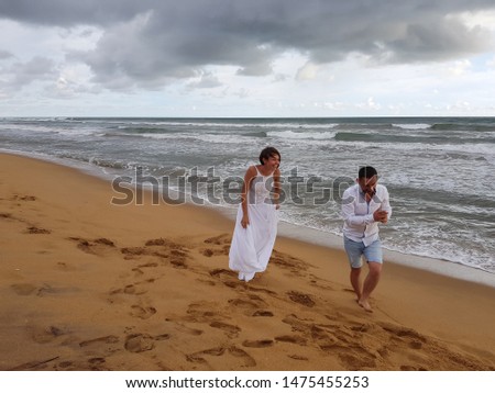 Young couple laughing and having fun on the sandy beach of a tropical ocean. The coast of Sri Lanka