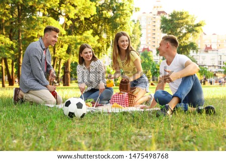 Young people enjoying picnic in park on summer day
