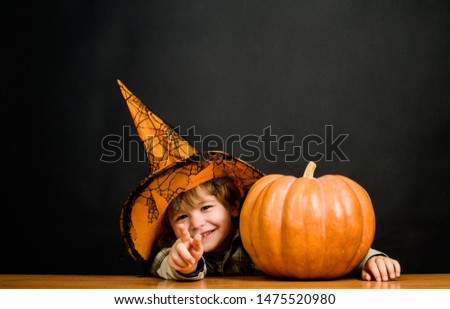 Halloween boy pointing to front. Child with pumpkin pointing at you. Little boy in witch hat with halloween pumpkin shows finger on you. Trick or treat. Preparation Halloween holiday. Halloween party.
