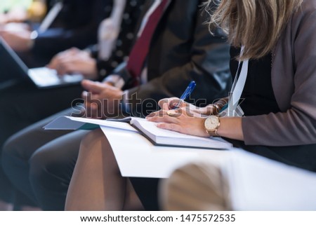 closeup shot of business people hands using pen while taking notes on education training during business seminar at modern conference room Royalty-Free Stock Photo #1475572535