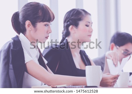 Group of young business people working, communicating while sitting at the office desk together with colleagues. Business people has stategic planning in office. Business concept.