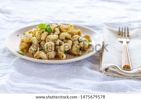 traditional soviet russian pasta dish, vermicelli, navy pasta, with meat on a white plate on a light fabric background. Minimalism View from above.