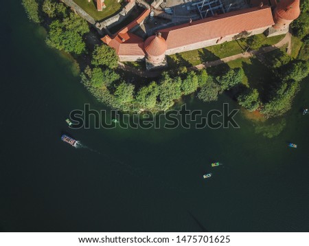Aerial view of water bikes with tourists swimming around Trakai castle, located in the middle of Galve lake.