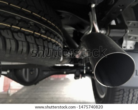 Spare tire under the car near exhaust pipe