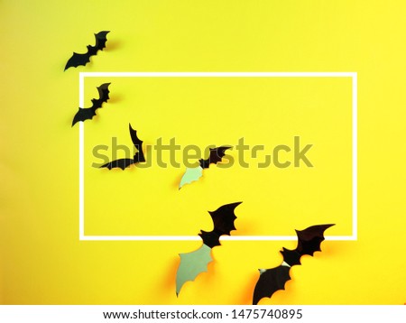 Halloween bats on orange and yellow background in neon toning with gradient with White Paper Frame.