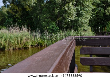 Photo of a beautiful river pier with a wooden walkway in the summer on the lake. Made outdoors in summer.