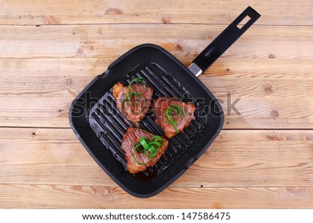 grilled beef fillet strips on grill teflon black plate over wood