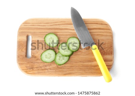 Wooden cutting board with cucumber slices and chef's knife isolated on white, top view