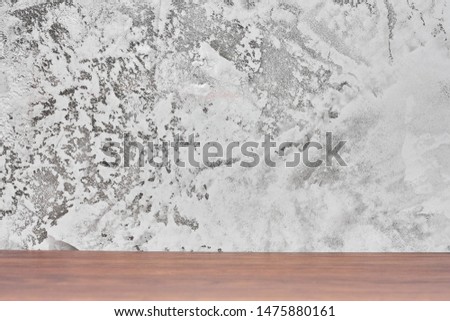 Wood table in front of cement wall, gray concrete loft style wall use for background.