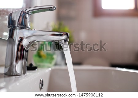 Open chrome faucet washbasin with high water pressure Royalty-Free Stock Photo #1475908112