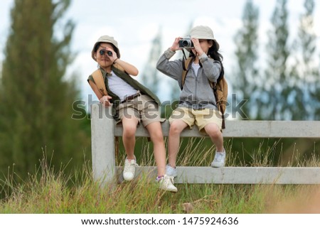 Asian two friend children take a photo and see binoculars for adventure and tourism for destination and leisure trips for education relax in jungle forest nature. Travel vacations Concept