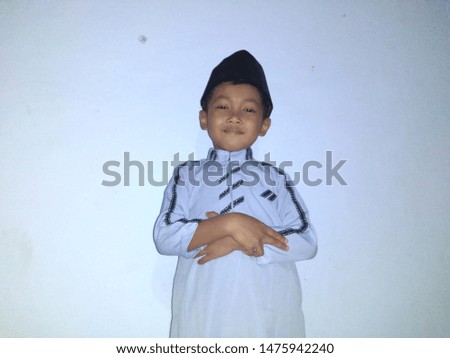 View of asian moslem kid praying pose againts white background