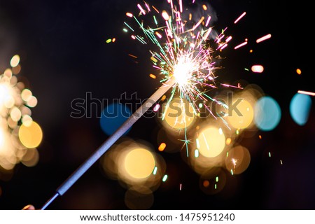 Burning sparkler, Happy New Year. Bengal fire sparkles against the background