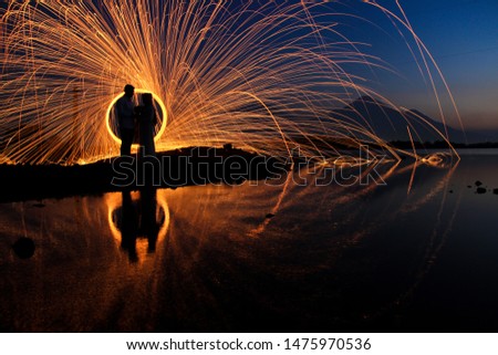the silhouette of a couple with a steel wool background. steel wool is a photography technique using steel fibers that are burned and rotated using slow speed techniques