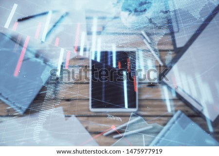Double exposure of forex chart and world map on digital tablet laying on table background. Concept of market analysis