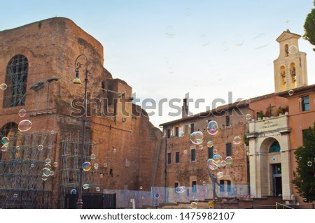 Ruins of Basilica di Massenzio and Santi Cosma e Damiano among many soap bubbles. Old town of Rome, Italy. Sunny autumn day. Shot from above