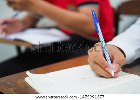 Written test conceptual picture of student writing assignment in classroom of educational institute, academy, high school, college, or university campus. Admission or university entrance examination 