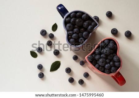 blueberries in cups in the shape of a heart on a white background