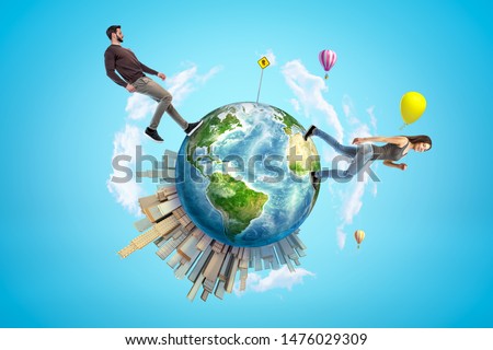 Young man and woman in casual clothes walking on small planet Earth with modern city popping up on one side and hot-air balloons flying in sky. Explore world. Travel more. Build world of your dream. Royalty-Free Stock Photo #1476029309