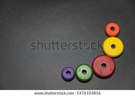 Round color sized wood circle for children training placed on black background top view