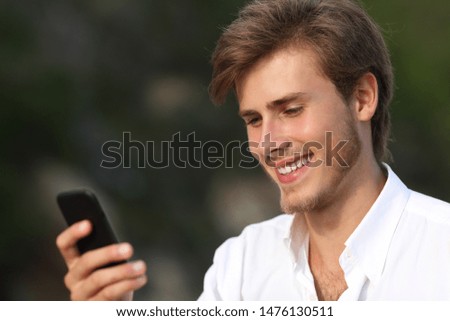 Happy teen using smart phone outdoors on dark background