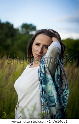 The girl in a grass field on a belt, poses and basked in the air