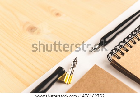 Calligraphy concept, accessories and tools for handwriting,ink, brush,writing training,blank sheets of white paper and cardboard crafting on wooden table,Top view, place for text