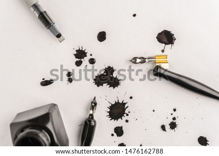 Calligraphy concept, pen for handwriting,spilled ink stains, brush,writing training,blank sheets of white paper ,Top view, place for text