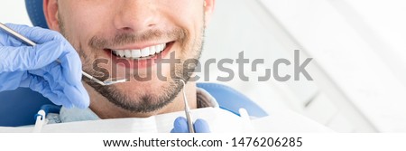 Young man at the dentist. Dental care, taking care of teeth. Picture with copy space for background. Royalty-Free Stock Photo #1476206285