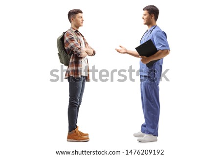 Full length profile shot of a male doctor in a blue uniform talking to a male student isolated on white background