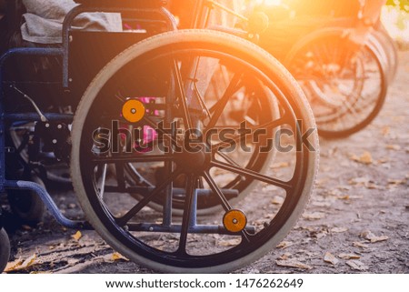 Disabled man resting in a campsite with friends. Wheelchair in the forest on the background of tents. Camping. Summertime