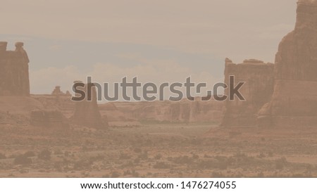 Faded background landscape photograph of Park Avenue rock formation area in Arches National Park