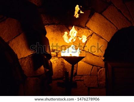 Flame from a torch in front of a brick medieval wall