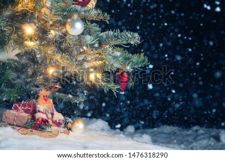 Christmas composition - Christmas tree in the snow, gifts, toy deer and the inscription Merry Christmas and Happy New Year, copy space, place for text