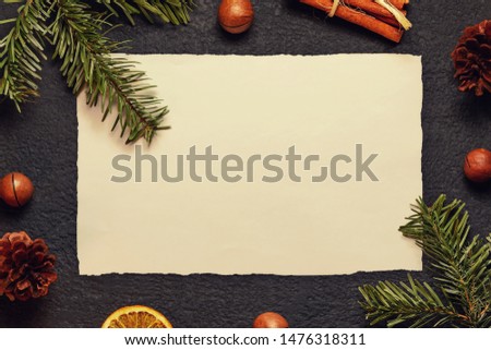 Christmas composition, blank for greeting card or other design - old paper with a Christmas tree branch and decorations on a dark background, flat lay, top view, copy space, place for text