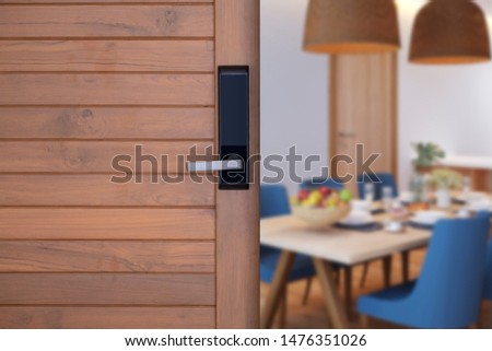  Digital knob door in front of blur living room background. Electronic door handle on wood door Hotel or apartment door half opened for looking to blur diningroom background, selective focus