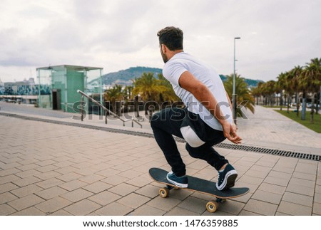Skateboarder rides a skateboard in the modern city street