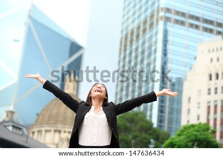 Business woman happy success outdoor in Hong Kong celebrating successful business with arms spread out winning. Young multiracial Chinese Asian / Caucasian female professional in central Hong Kong Royalty-Free Stock Photo #147636434