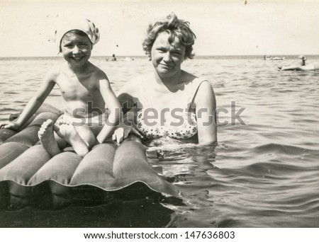 Vintage photo of woman and little girl bathing in sea, fifties