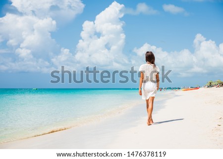 Caribbean beach luxury vacation summer holiday woman walking on perfect white sand tourist destination. Royalty-Free Stock Photo #1476378119