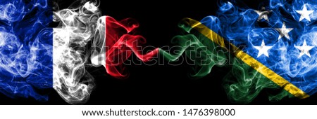 France vs Solomon Islands smoky mystic flags placed side by side. Thick colored silky abstract smokes banner of French and Solomon Islands