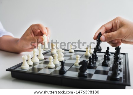 hand of businessman moving chess in competition, shows leadership, followers and business success strategies.